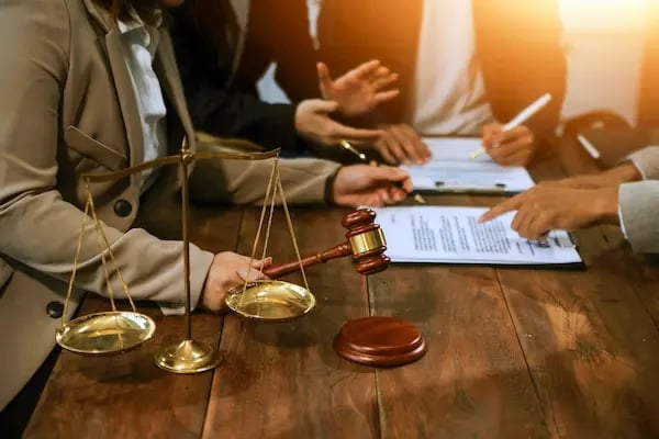 manos de abogados con mazo en escritorio