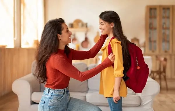 madre preparando a su hija para su primer dia 